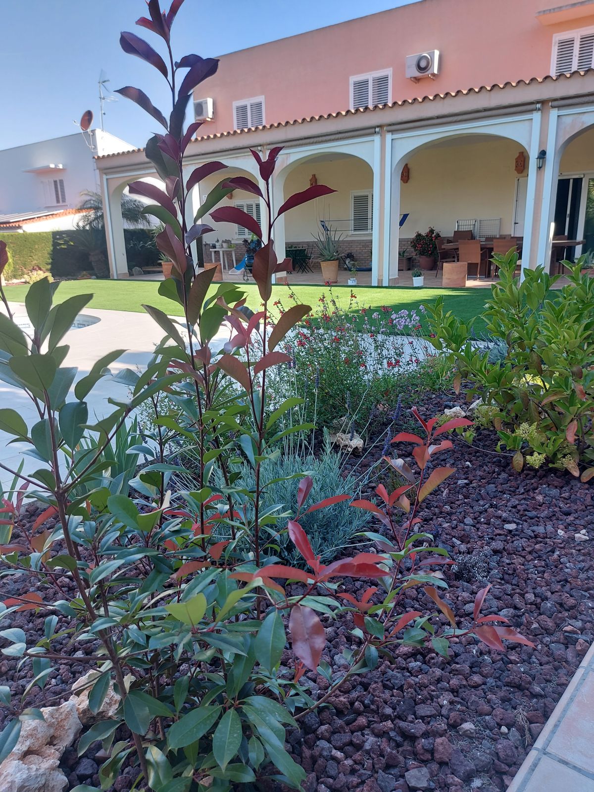 Jardín mediterráneo con arbolado y zona de estar en una vivienda de Espartinas